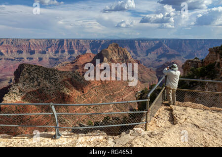 A tourist admiring the view from the Cape Royal viewpoint towards Freya Castle & Vishnu Temple, Grand Canyon North Rim, Arizona, United States. Stock Photo