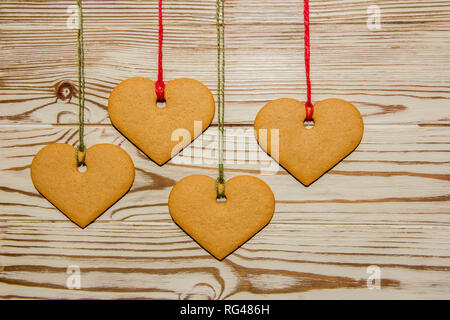 Handmade heart shaped cookies, tied to a rope on a wooden background  for a Valentine, Christmas or any holiday of loving people Stock Photo