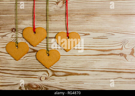 Handmade heart shaped cookies, tied to a rope on a wooden background  for a Valentine, Christmas or any holiday of loving people Stock Photo