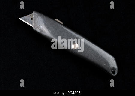 gray carpet utility knife on black background Stock Photo