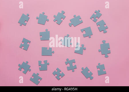 Puzzles on a pink background as a symbol of autism. Conceptual vision of the problem of autistic children Stock Photo