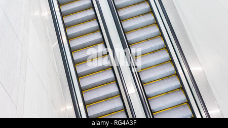 Both sets of up and down escalators in a hotel convention center with no one riding them.  and down escaltors in a hotel convention center with no one Stock Photo