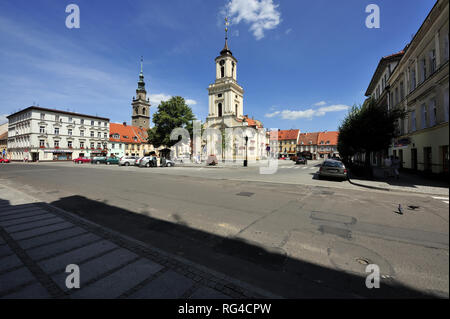 Ratusz (Town Hall), 1781, Neoclassical style, street lamp decorated with geraniums, Church of SS Peter and Paul behind, summer, in Swiebodzice, Lower Stock Photo