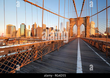 Brooklyn Bridge over East River viewed from New York City Lower Manhattan waterfront at sunset. Stock Photo