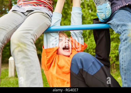 Kids have fun on a jungle gym in the park in the summer and play and silly Stock Photo