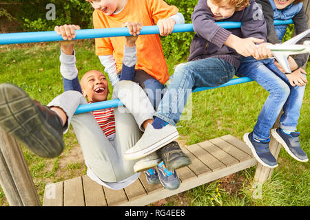 Group of kids is having fun climbing and playing on a jungle gym in the park Stock Photo