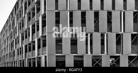 Ugly grey multi-storey car park for safe parking and parking of vehicles in front of the city gates. Stock Photo