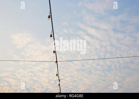 Light bulbs on string wire with blue sky Stock Photo