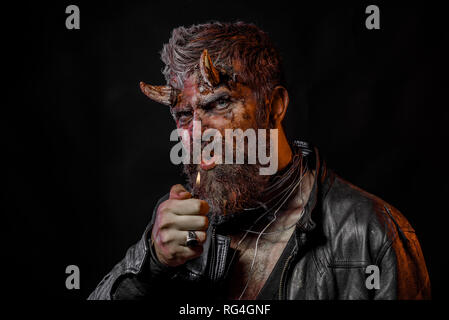 Halloween man devil blow out fire on black background Stock Photo