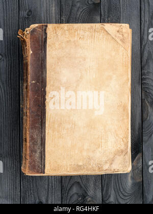 Old book with blank cover on the wooden table. Top view, copy space on the book cover Stock Photo
