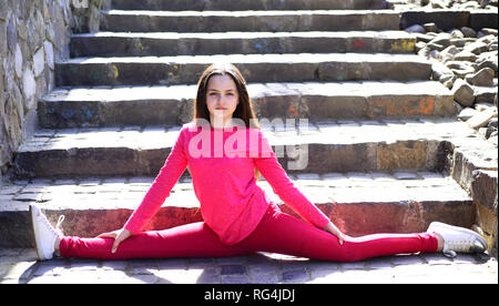 A good stretching regime. Cute gymnast practicing yoga or pilates. Little  girl doing split outdoor. Small child girl stretching legs muscle. Fit  child Stock Photo - Alamy