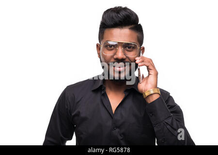 Young Indian man talking on mobile phone isolated against white background Stock Photo