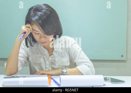 Asian manager exhausted and frustrated after checking many sales reports Stock Photo