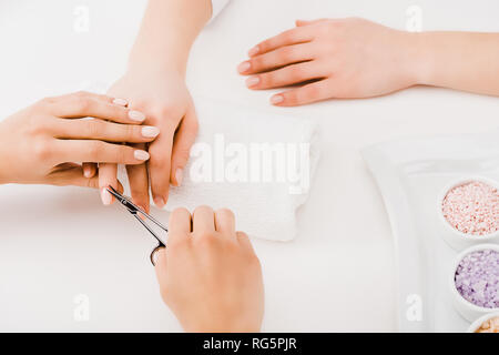 Cropped view of manicurist cutting cuticles with scissors Stock Photo