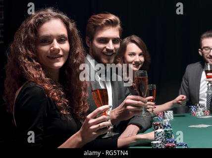 Poker players sitting around a table at a casino Stock Photo