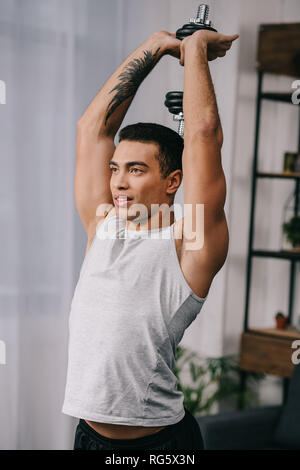muscular bi-racial man with tattoo workout with dumbbell Stock Photo - Alamy