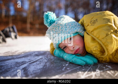 Portrait of a girl lying on a frozen pond, United States Stock Photo