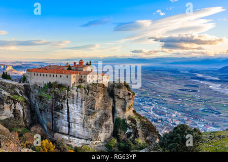 Agios Stephanos or Saint Stephen monastery located on the huge rock with mountains and town landscape in the background, Meteors, Trikala, Thessaly, G Stock Photo