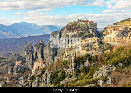 Four monasteries of Meteors: Roussanou, Monastery of Agios Nikolaos Anapafsas, Varlaam and Grand Meteora scattered on the steep cliffs with mountains  Stock Photo