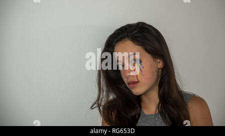 Young teen with colorful tear drops painted on her face Stock Photo