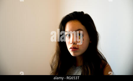 Young teen with colorful tear drops painted on her face Stock Photo