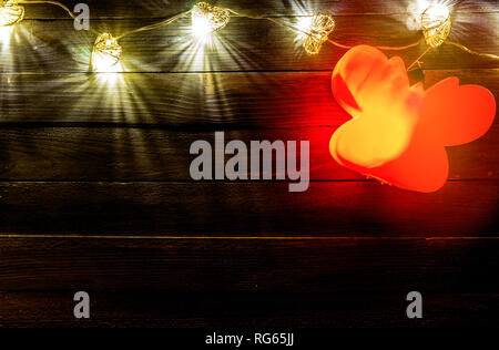 Hearts shaped string lights on wooden table backdrop, space for advertising Stock Photo