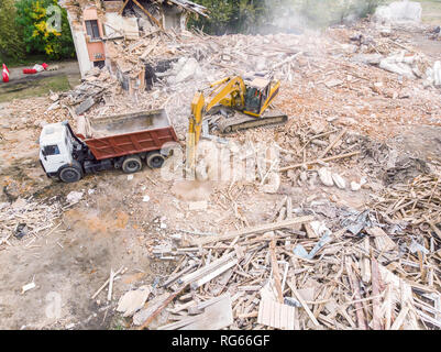 excavator and dump truck clearing out site after demolition of old ...
