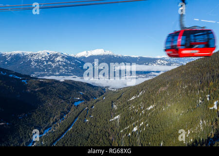 A large gondola car streaking by with the valley in between Whistler and Blackcomb in the background. Stock Photo