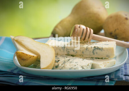 Sliced blue cheese, ripe fresh pears and honey on a honey dipper Stock Photo