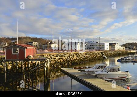 Red boathouse and some recreational crafts in the smooth water of a small marina in the Norwegian town Brønnøysund, 11 March 2017 | usage worldwide Stock Photo