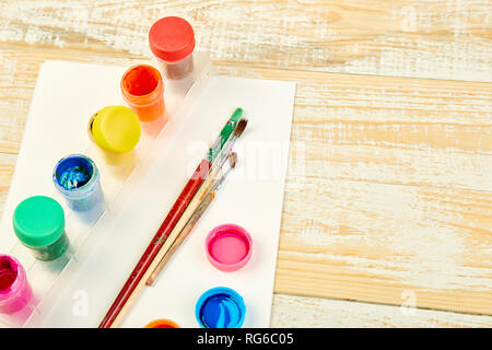 Watercolor palettes and paint brushes. Artist workplace on a wooden background. Minimal. Creative. Flat lay. Top view. Copy space. Stock Photo