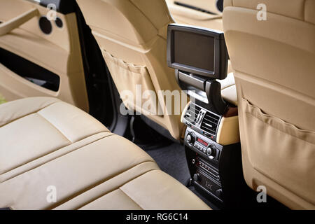 Car inside. Interior in cream colors leather of prestige luxury modern car. Swivel display for back seats passenger with media control panel copy spac Stock Photo