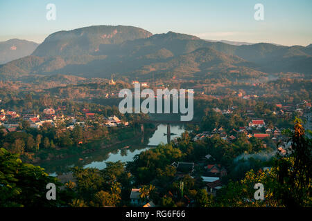 Sunset in Lunag Prabang, Laos. Beautiful clouds over the city. Mekong river between trees and houses. Winter in Laos Stock Photo