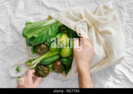 Concept Of Conscious Consumption. Fresh Organic Food Coming Out From Fabric Eco Shopping Bag, Top View, Flat Lay Stock Photo