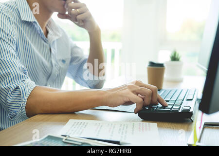 Serious busy hipster young web software developer programmer is coding or programming on a desktop computer information in modern office technologies  Stock Photo