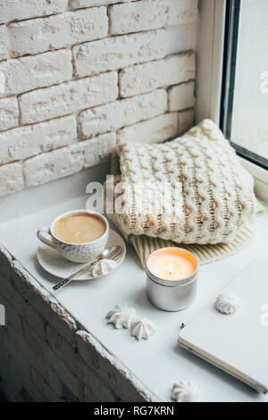 Cozy winter home interior with knitted blanket and candle Stock Photo