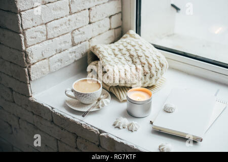 Cozy winter home interior with knitted blanket and candle Stock Photo