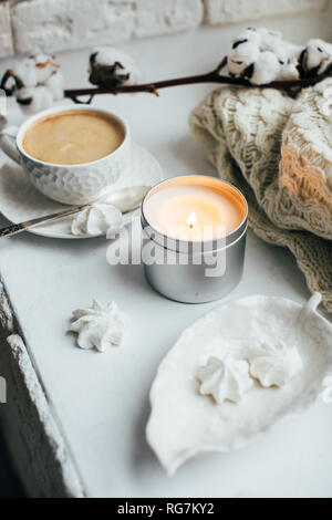 Cozy winter home interior with knitted blanket and candle Stock Photo