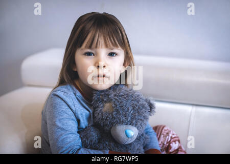 Portrait of little girl. Kid sad face sitting alone in the room. Stock Photo