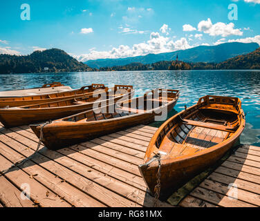 Traditional wooden boats Pletna on the backgorund of Church on the Island on Lake Bled, Slovenia. Europe. Stock Photo