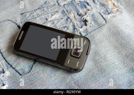 Old Used retro cell mobile phone on fabric Stock Photo