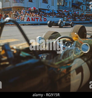 Der Brite Jackie Stewart fährt an Jack Brabhams Wagen im Boxenstopp vorbei beim Großen Preis von Monaco, 1966. British racing driver Jackie Stewart overtaking Jack Brabham at the pit stop at the Grand Prix of Monaco, 1966. Stock Photo