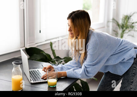 Young woman using laptop at home Stock Photo