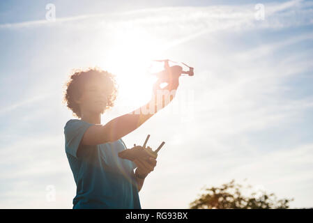 Boy flying a drone outdoors Stock Photo