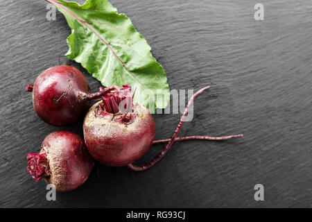 whole young beets on the table, on a black background. space for text Stock Photo