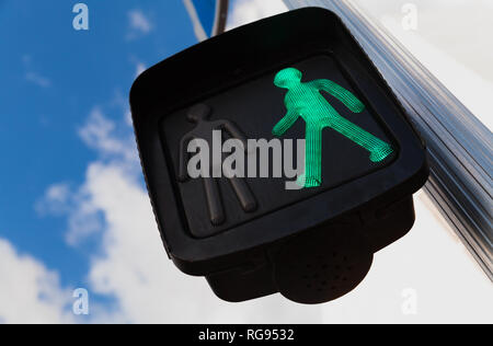 Pedestrian crossing traffic lights under blue cloudy sky show green allow signal to go Stock Photo