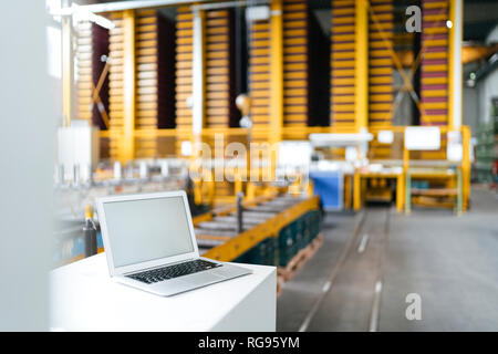Laptop with blank screen in logistics center Stock Photo