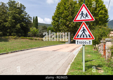 Pedestrian Crossing and Caution children, road signs mounted on one pole near rural road Stock Photo