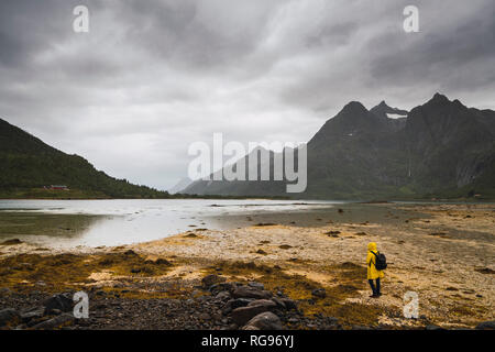 Young man standing at a lake in Vesteralen Island, Lapland, Norway Stock Photo