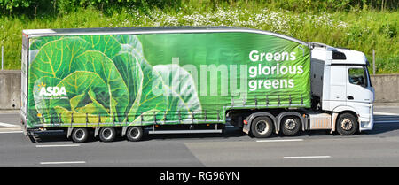 Asda supermarket food supply chain delivery lorry truck & greens cabbage vegetables slogan advertising on side of long articulated trailer UK motorway Stock Photo